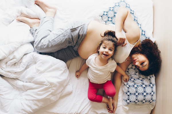 Madre embarazada junto a su hija, compartiendo un momento en familia